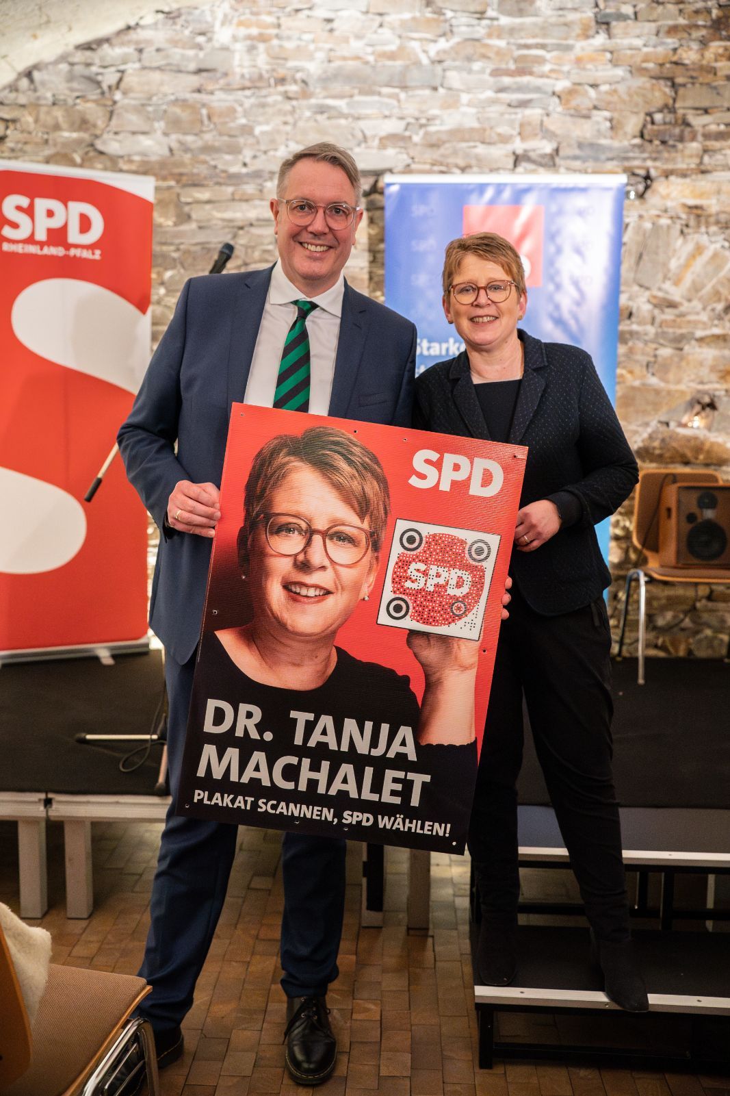 Alexander Schweitzer und Tanja Machalet Halten zusammen ein Wahlplakat aus dem Tanja Machalet zu sehen ist
